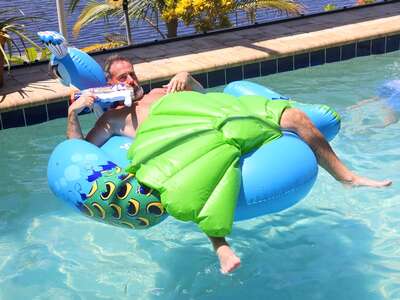 [Translate to deutsch:] Chris genießt den Morgem im privaten Pool auf einer Luftmatratze in Cape Coral - Florida