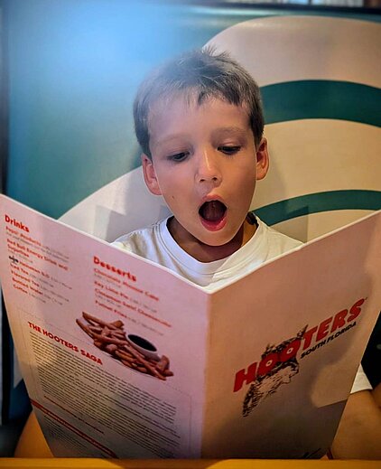 Hooters restaurant – child looking at the menu with wide eyes