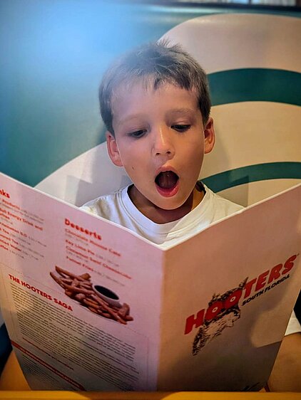 Hooters Restaurant - Kind liest mit großen Augen die Hooters Speisekarte